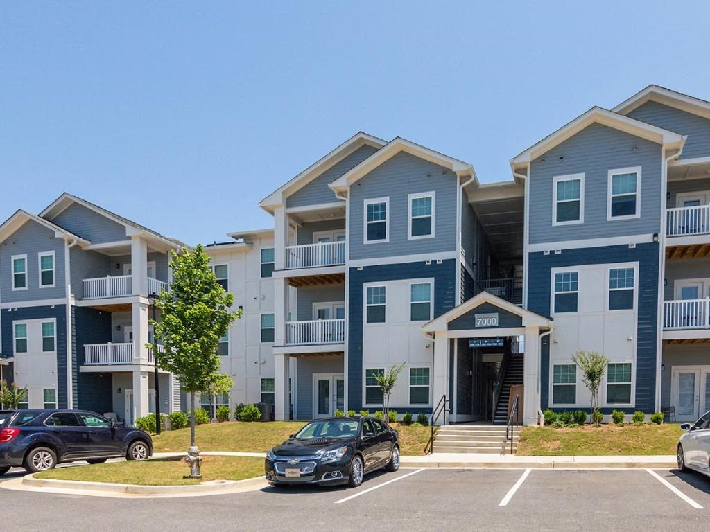 an apartment building with cars parked in front of it