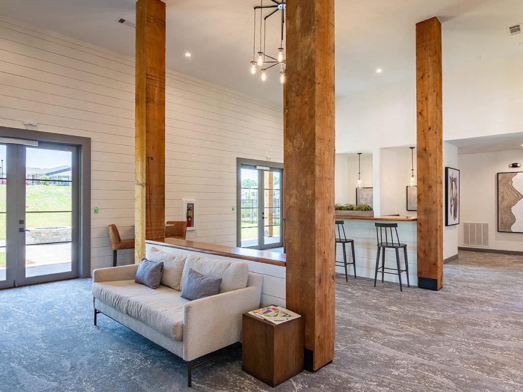 a living room with a couch and a kitchen with a bar