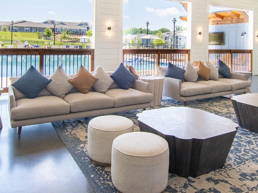 a living room with couches and tables and a balcony