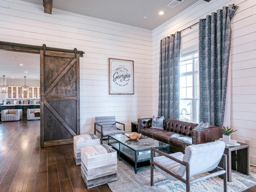 a living room with a couch and chairs and a sliding barn door
