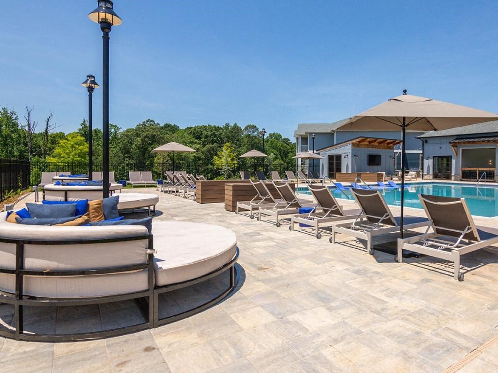a swimming pool with lounge chairs and umbrellas