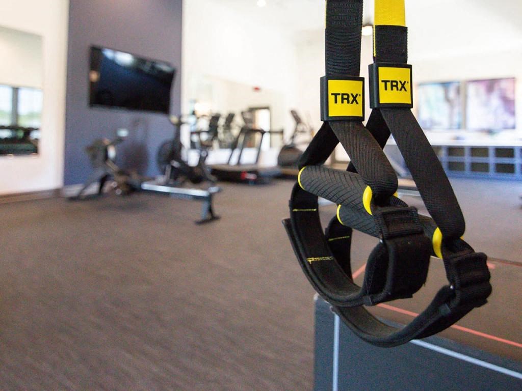 a gym with ropes and weights in it with a tv in the background