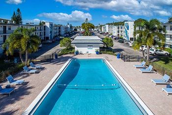 an aerial view of a swimming pool with chairs around it