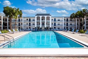 a large swimming pool in front of an apartment building