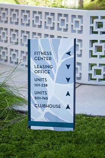 a sign for a fitness center leasing office on the grass