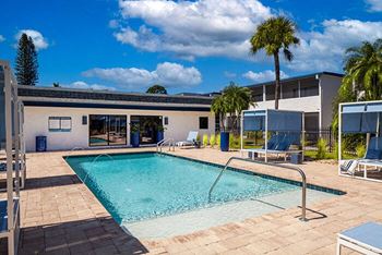 a swimming pool and a building with palm trees