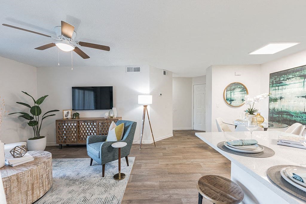 a living room and kitchen with a ceiling fan