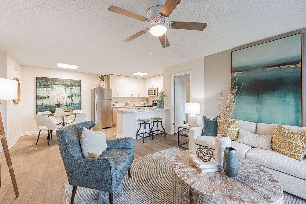 a living room and kitchen with a ceiling fan