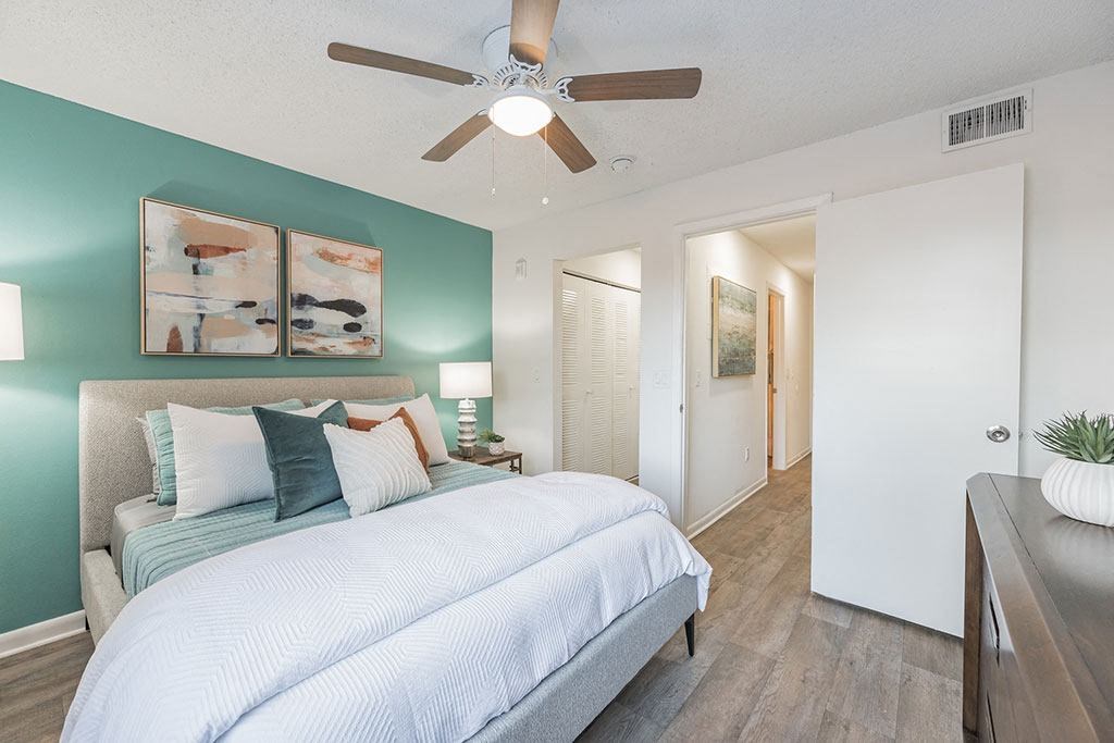 a bedroom with a bed and a ceiling fan