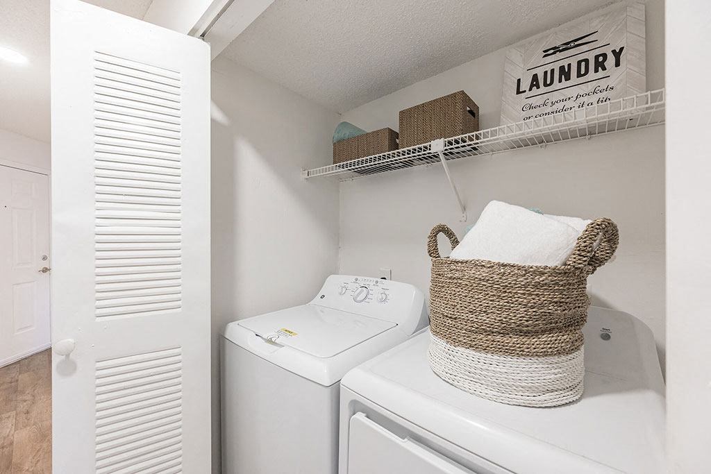 a white washer and dryer in a laundry room with a basket