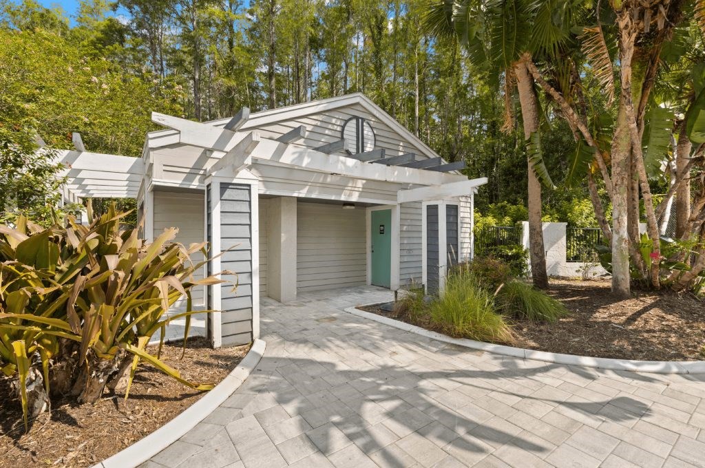 a small house with a driveway and a green door