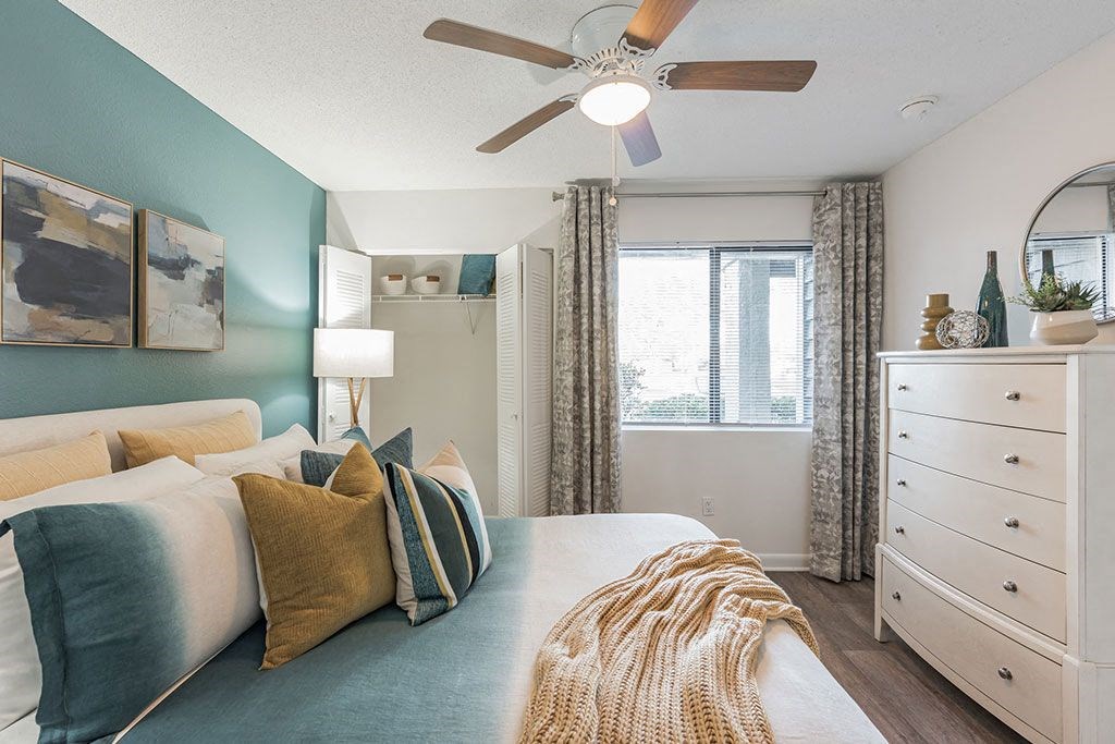 a bedroom with a bed and a ceiling fan