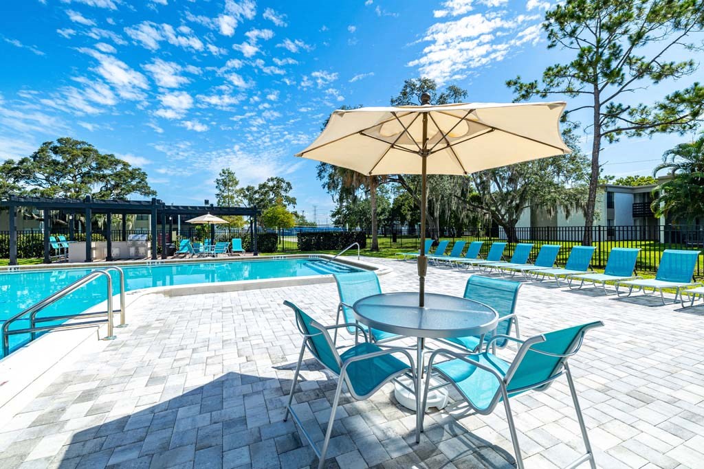 our apartments have a pool and patio with chairs and umbrellas