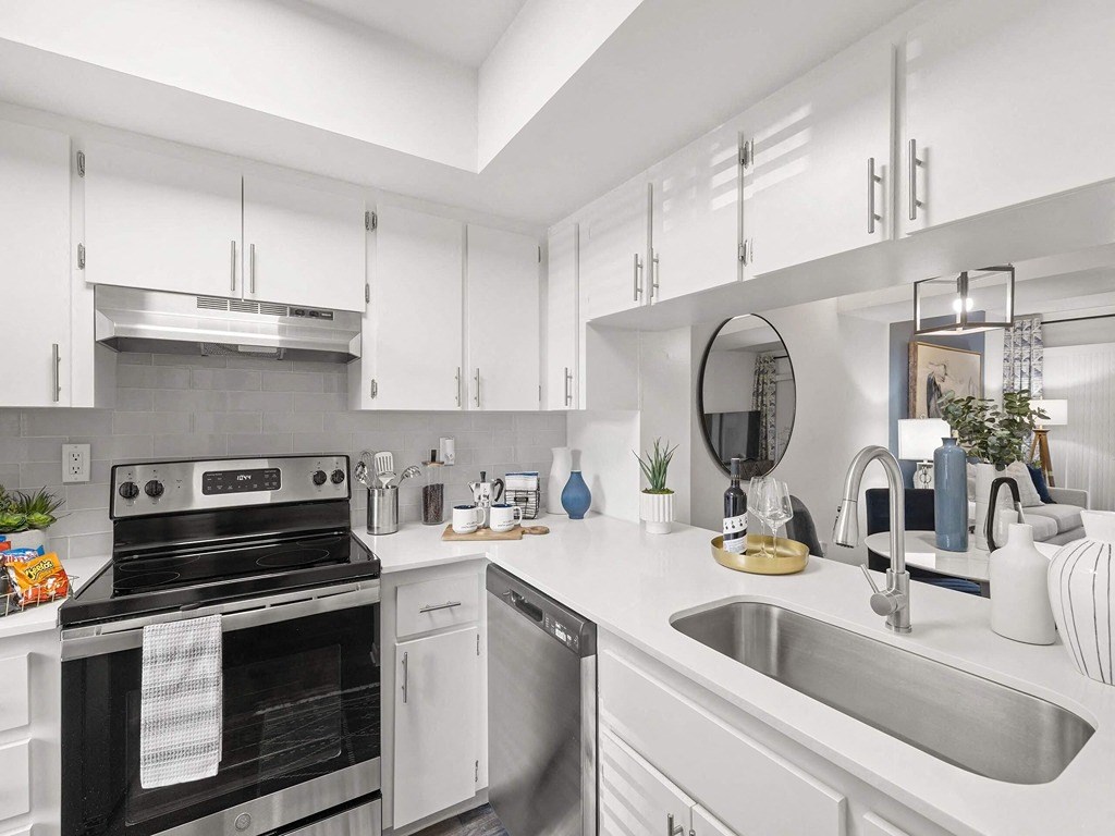 Ample  white kitchen with stainless steel appliances and a sink