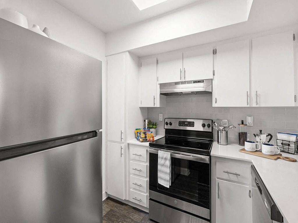 a kitchen with stainless steel appliances and white cabinets