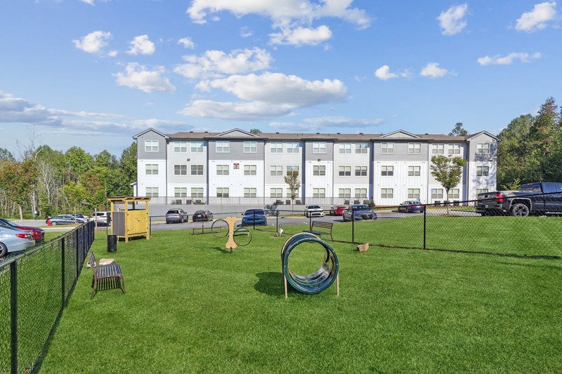 a playground with a swing set in front of an apartment building