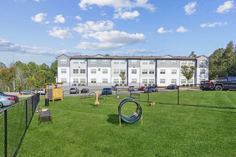 a playground with a swing set in front of an apartment building