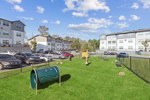 a park with cars parked in front of apartment buildings