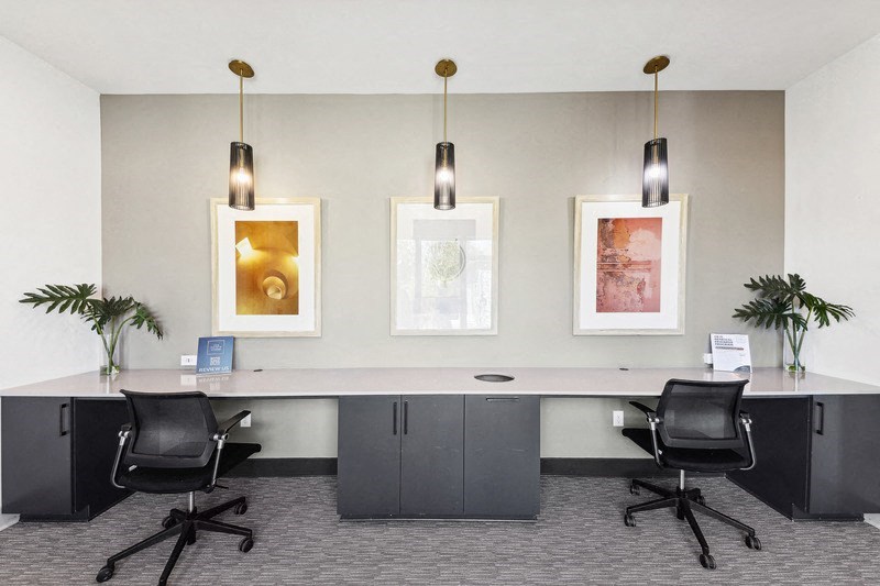 a conference room with desks and chairs and pictures on the wall