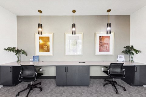 a conference room with desks and chairs and pictures on the wall