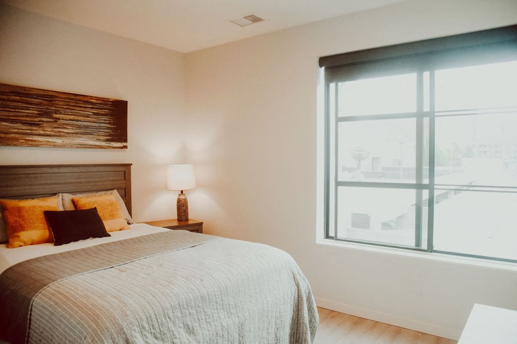 a bedroom with a bed and a large window