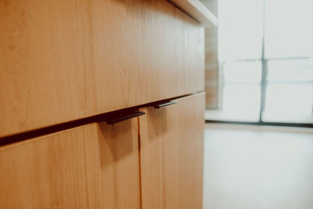 a kitchen with wood cabinets and a window
