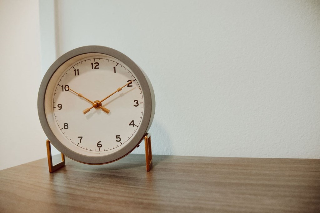 a clock sitting on top of a wooden table