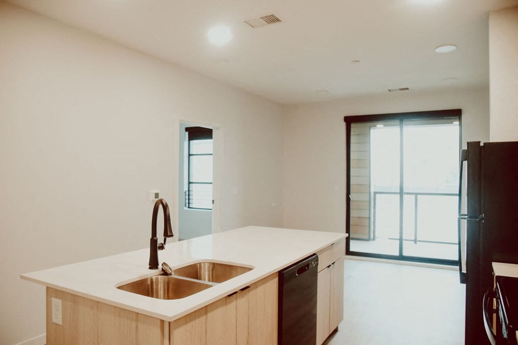 a kitchen with a sink and a refrigerator and open window