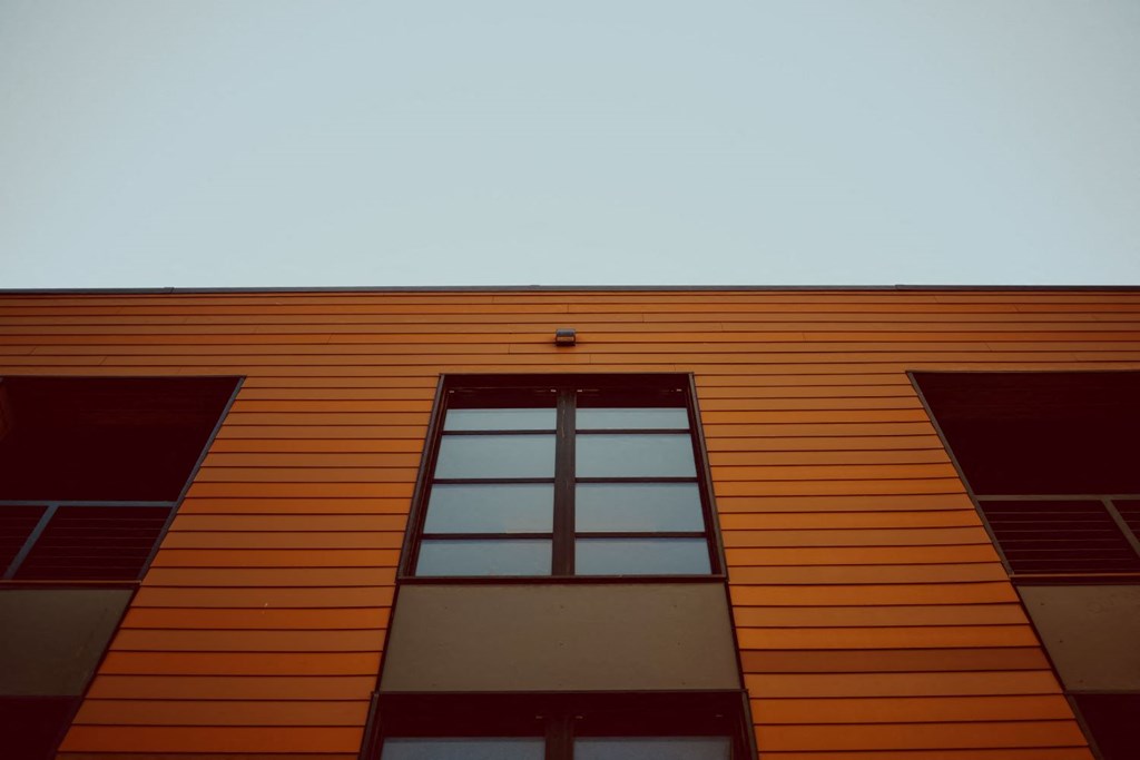 an orange building with a window and a blue sky
