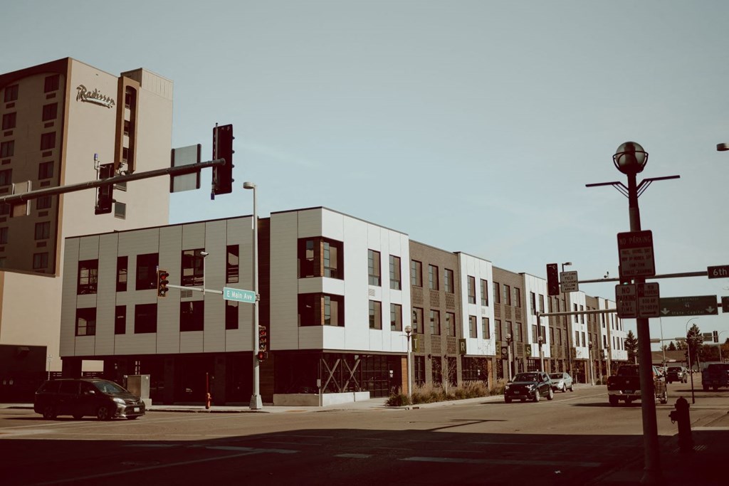 a city street with cars and buildings and traffic lights