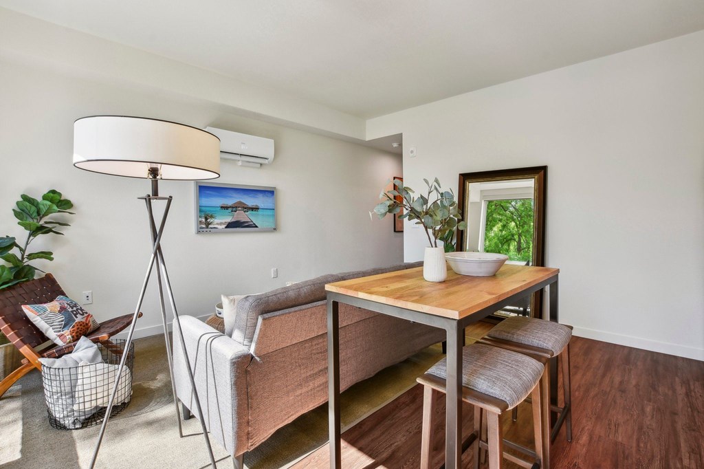 A living room with a couch, a table, and a painting on the wall.