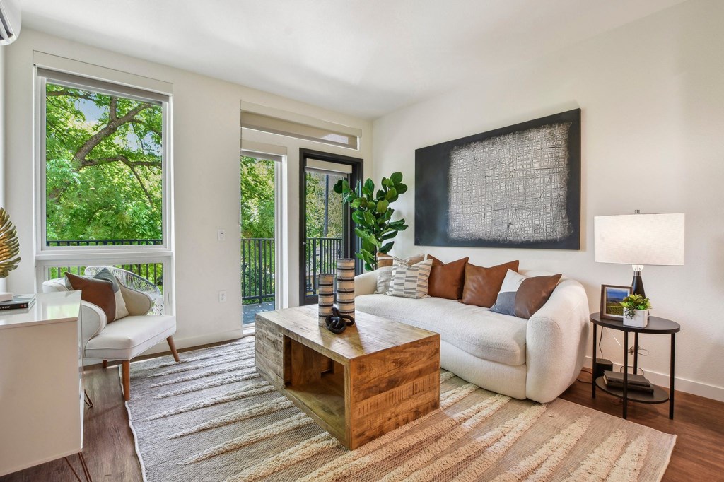 A living room with a white couch and a wooden coffee table.