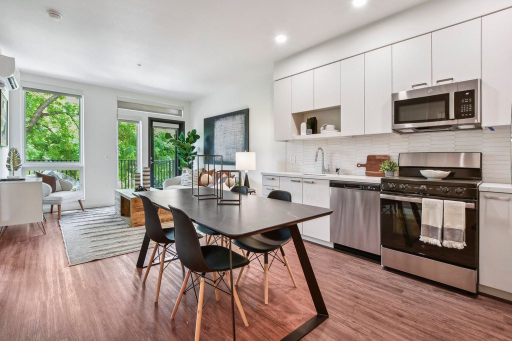 A modern kitchen with a dining table and chairs.