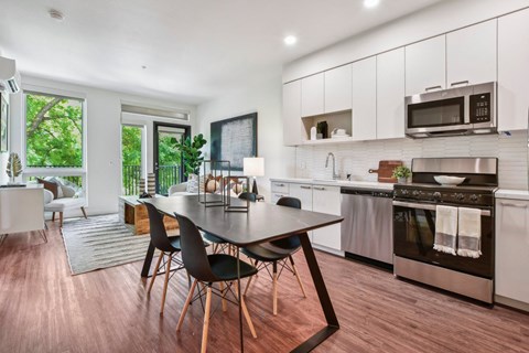 A modern kitchen with a dining table and chairs.