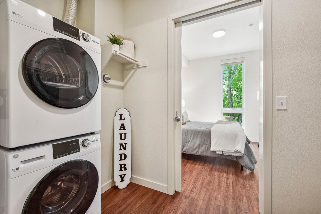 A laundry sign is on the wall next to a bed in a small room.