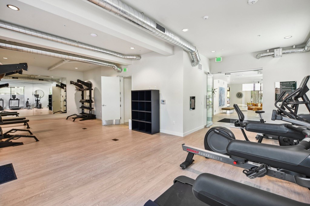 A gym with treadmills, weights, and exercise equipment.