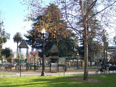 a childrens park with a playground and trees