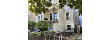 a white house with a balcony and a black fence