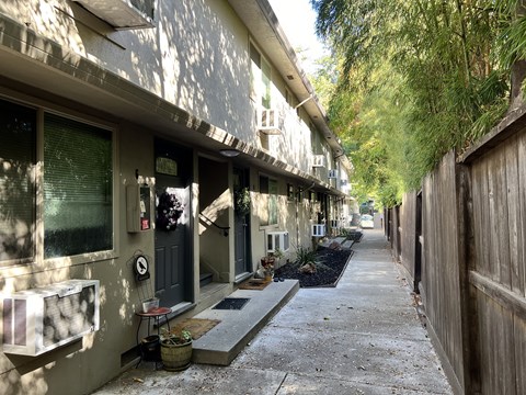 A narrow alley with a wooden fence on the right side.