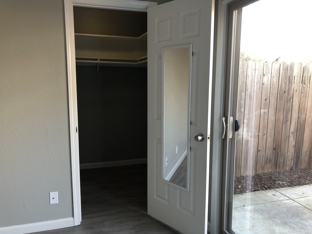the door to the closet is open to the backyard with a wooden fence