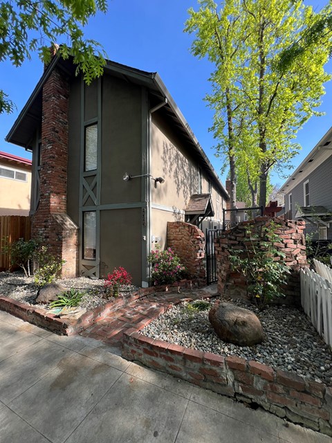 A house with a green door and a brick wall.