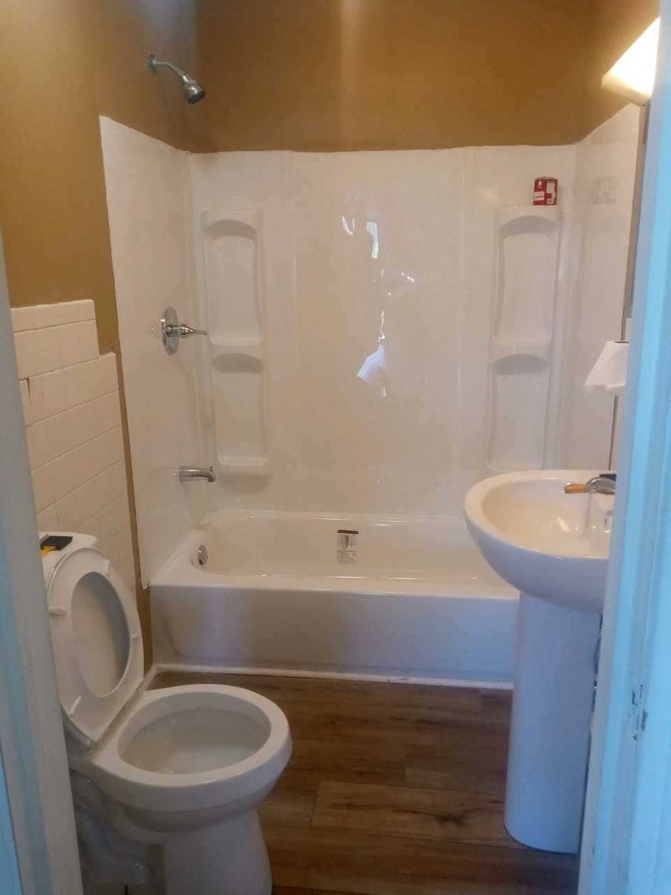 a bathroom with a toilet and a sink and a bath tub
