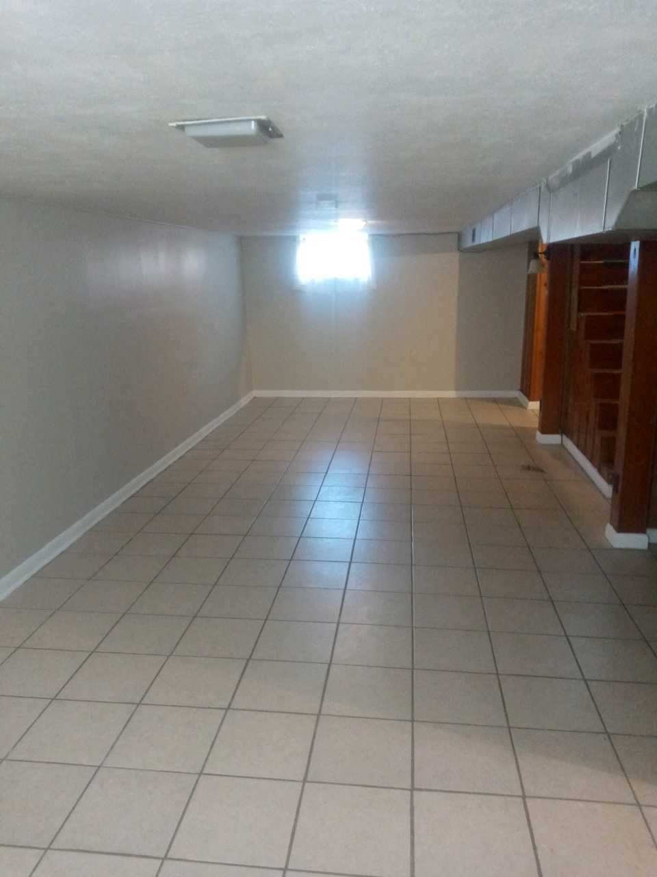 an empty room with a tiled floor and white walls