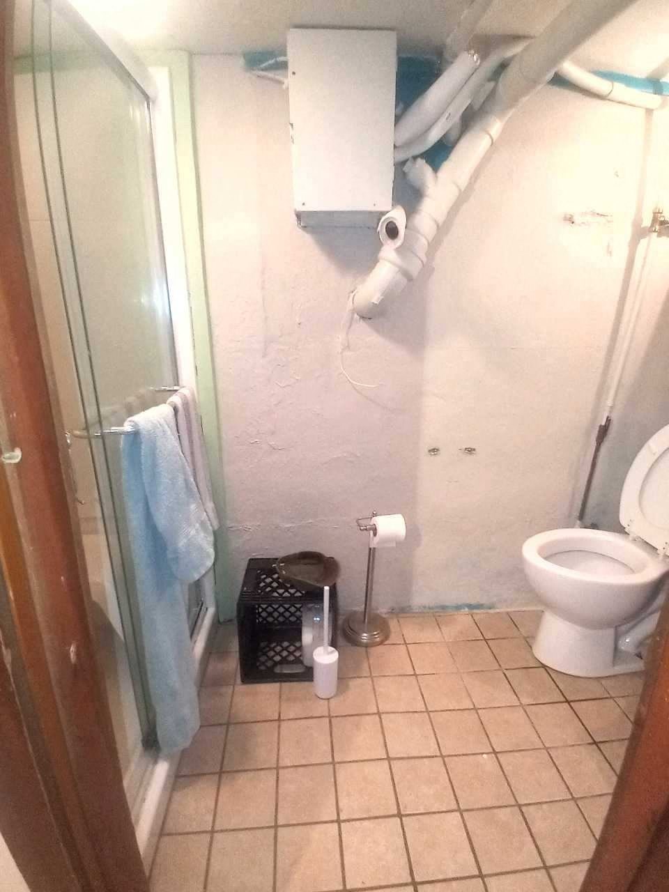 a bathroom with a toilet and a shower