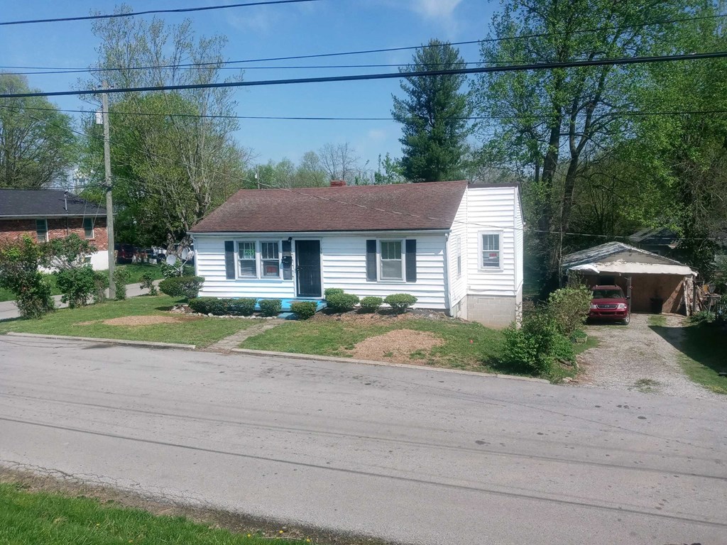 a white house with a red car parked in front of it