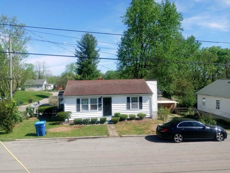 a white house with a black car parked in front of it