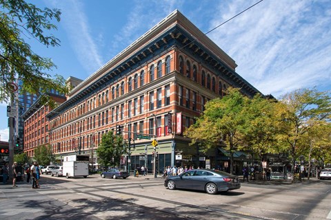 A large red brick building with a green tree in front of it.