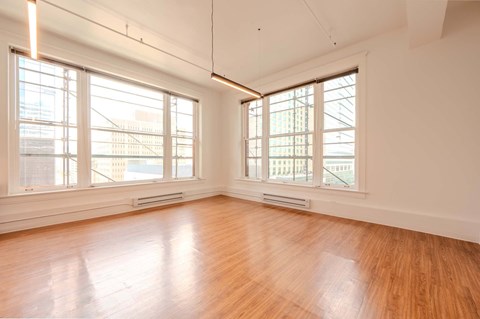 A room with wooden floors and large windows.