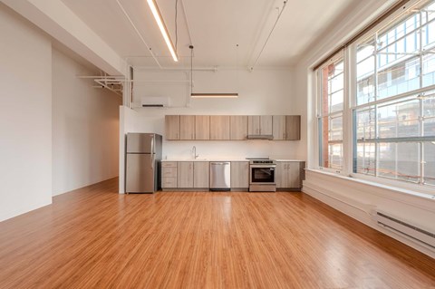 A kitchen with wooden floors and stainless steel appliances.