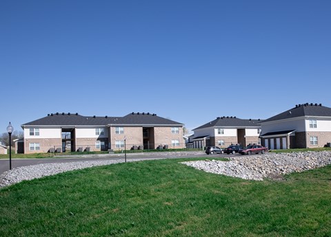 A row of houses with a grassy area in front.